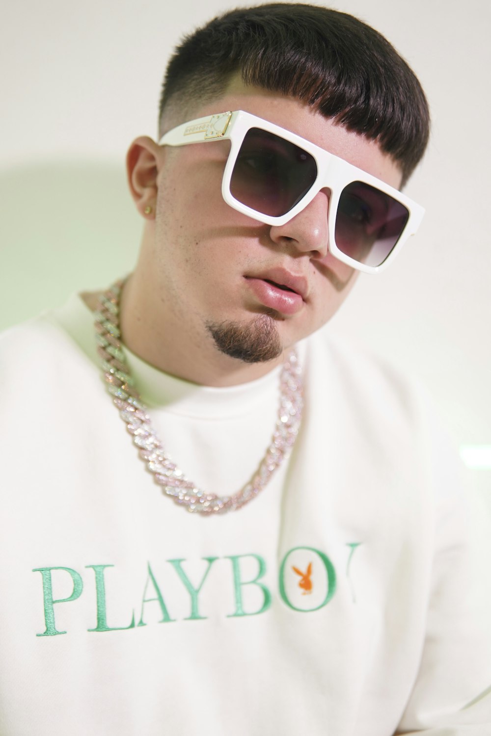 Foto Hombre con camisa blanca de cuello redondo y gafas de sol con montura  blanca – Imagen Rap gratis en Unsplash
