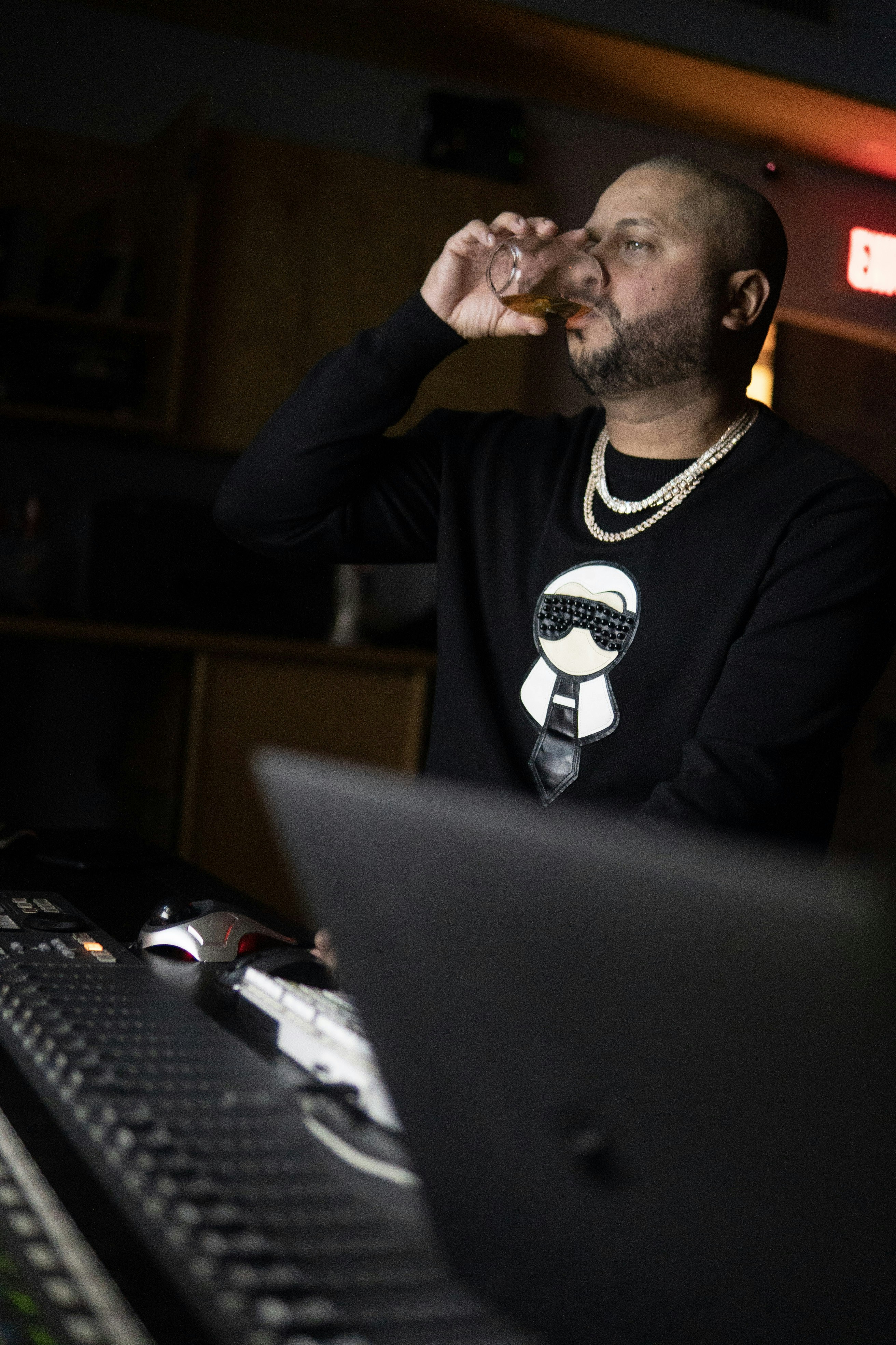 man in black and white sweater sitting in front of black laptop computer