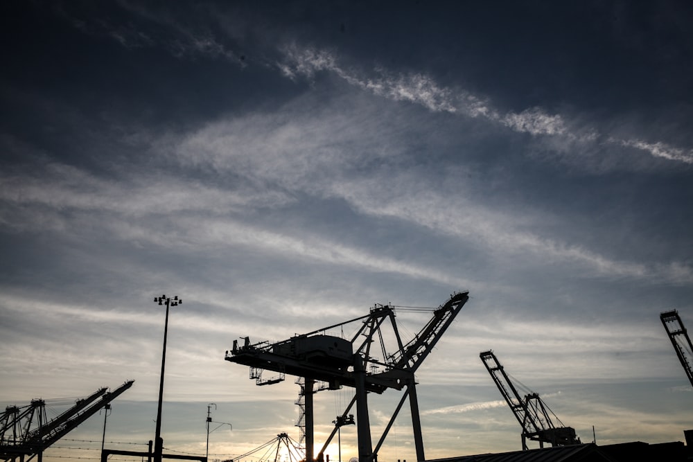 silhouette of crane under blue sky during daytime