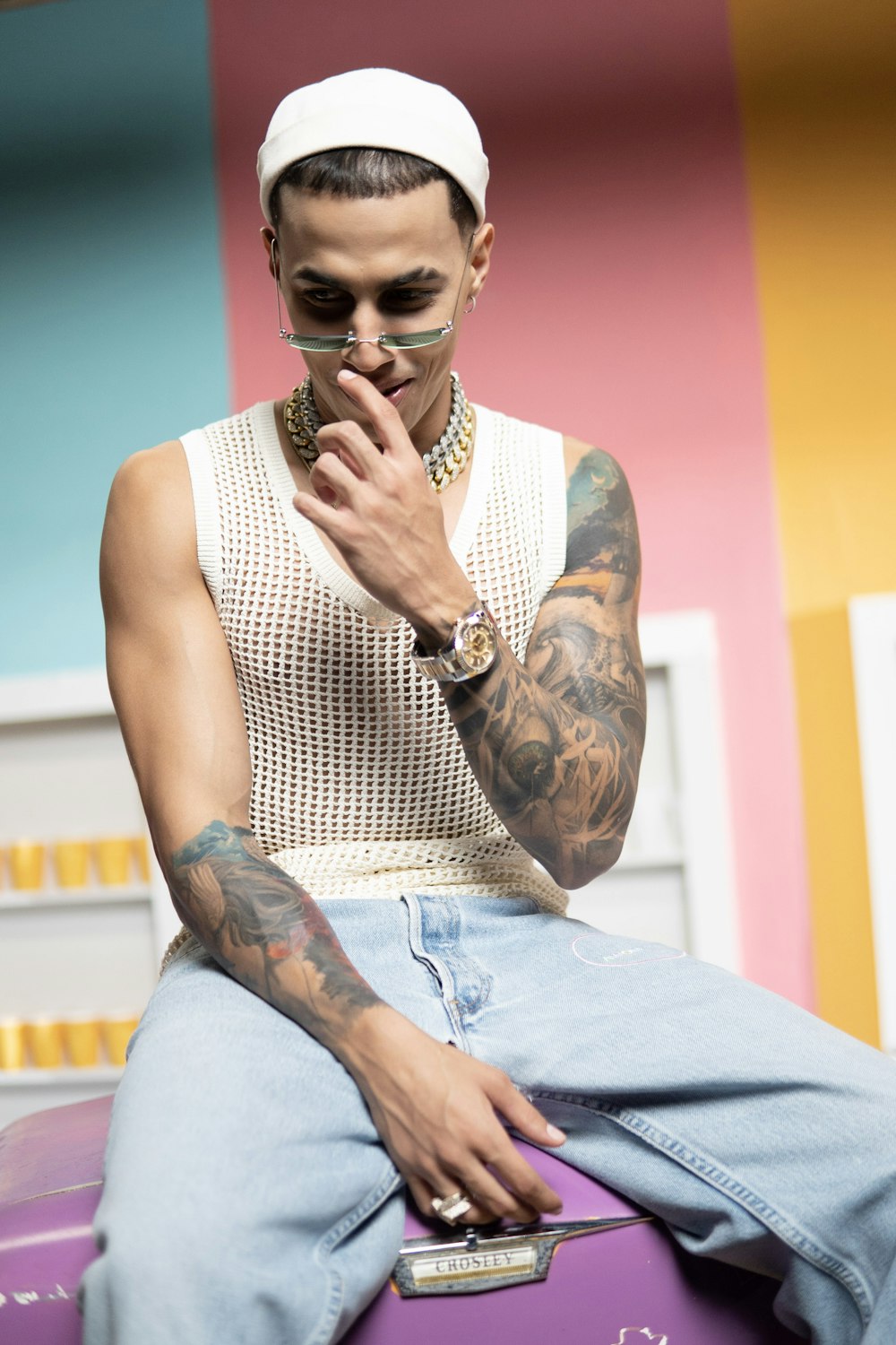 woman in white and black tank top and blue denim jeans sitting on chair