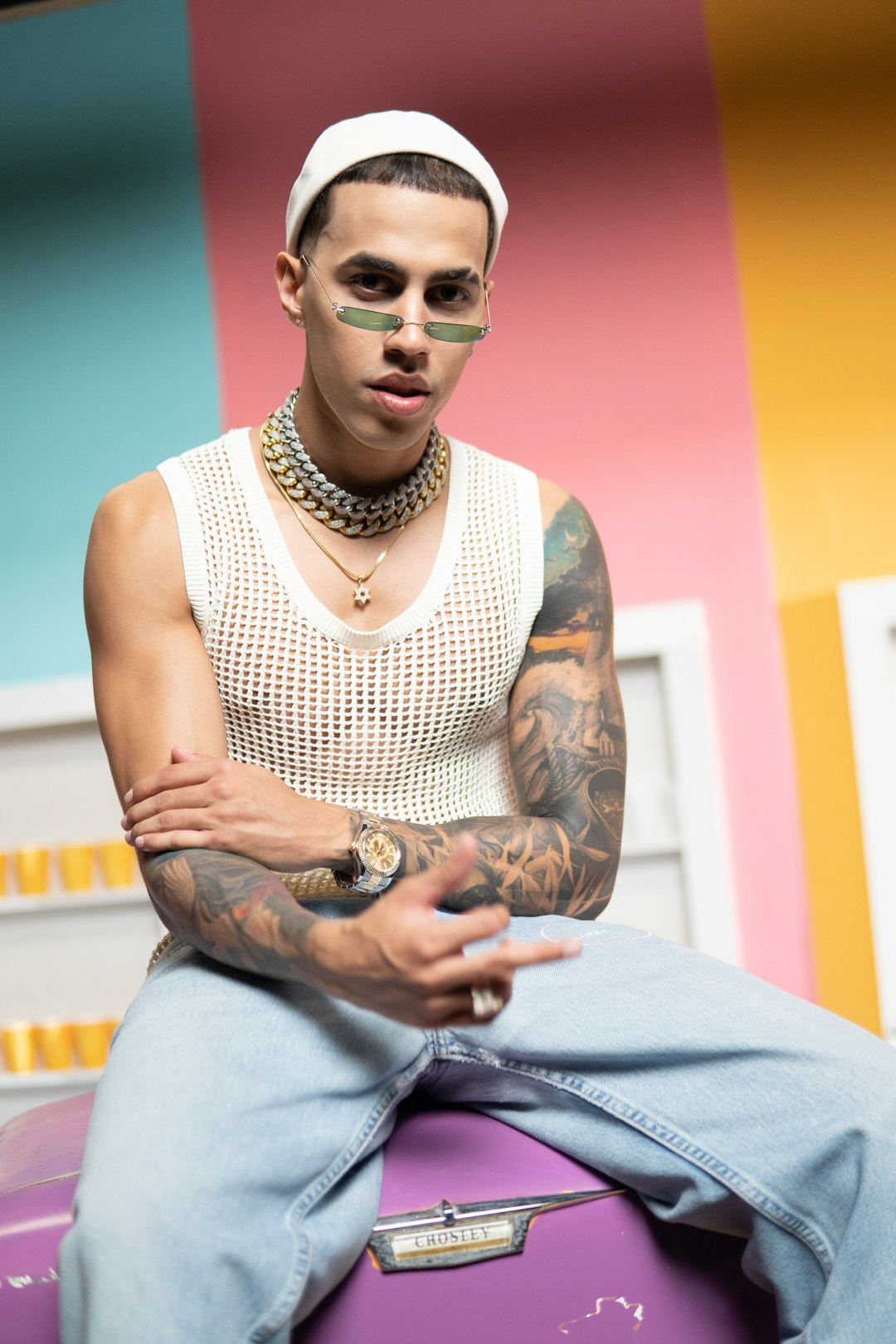 man in white tank top and gray pants sitting on blue bed