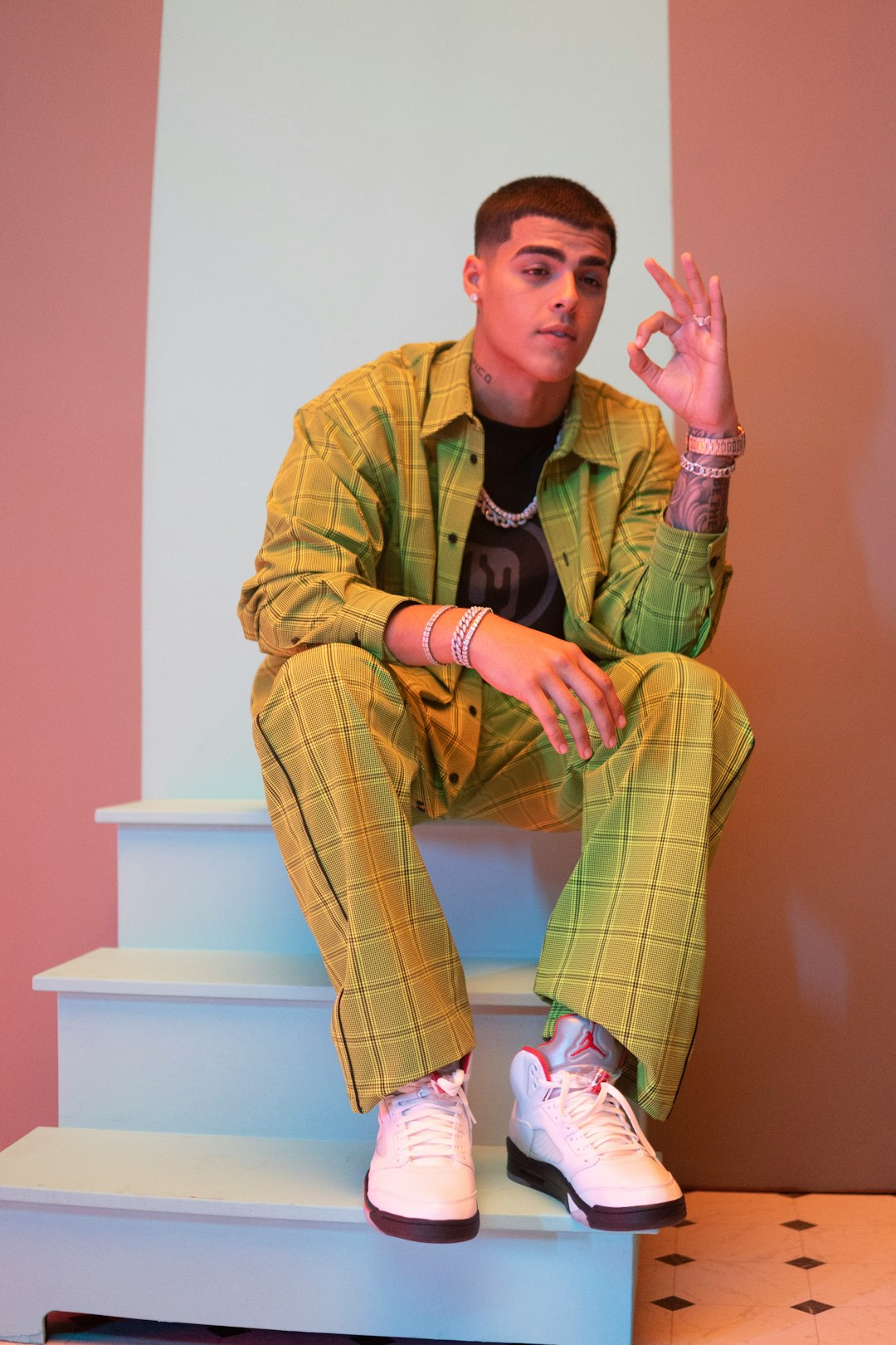 man in yellow and black striped long sleeve shirt sitting on white plastic chair