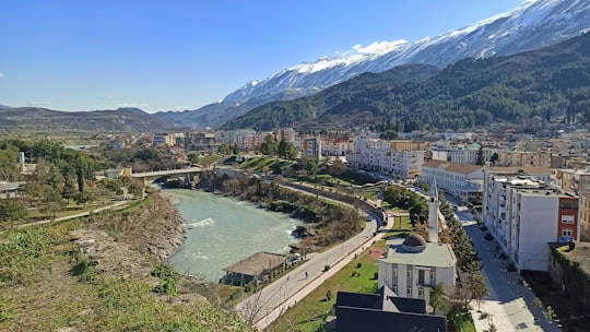 aerial view of city near lake during daytime in Përmet Albania