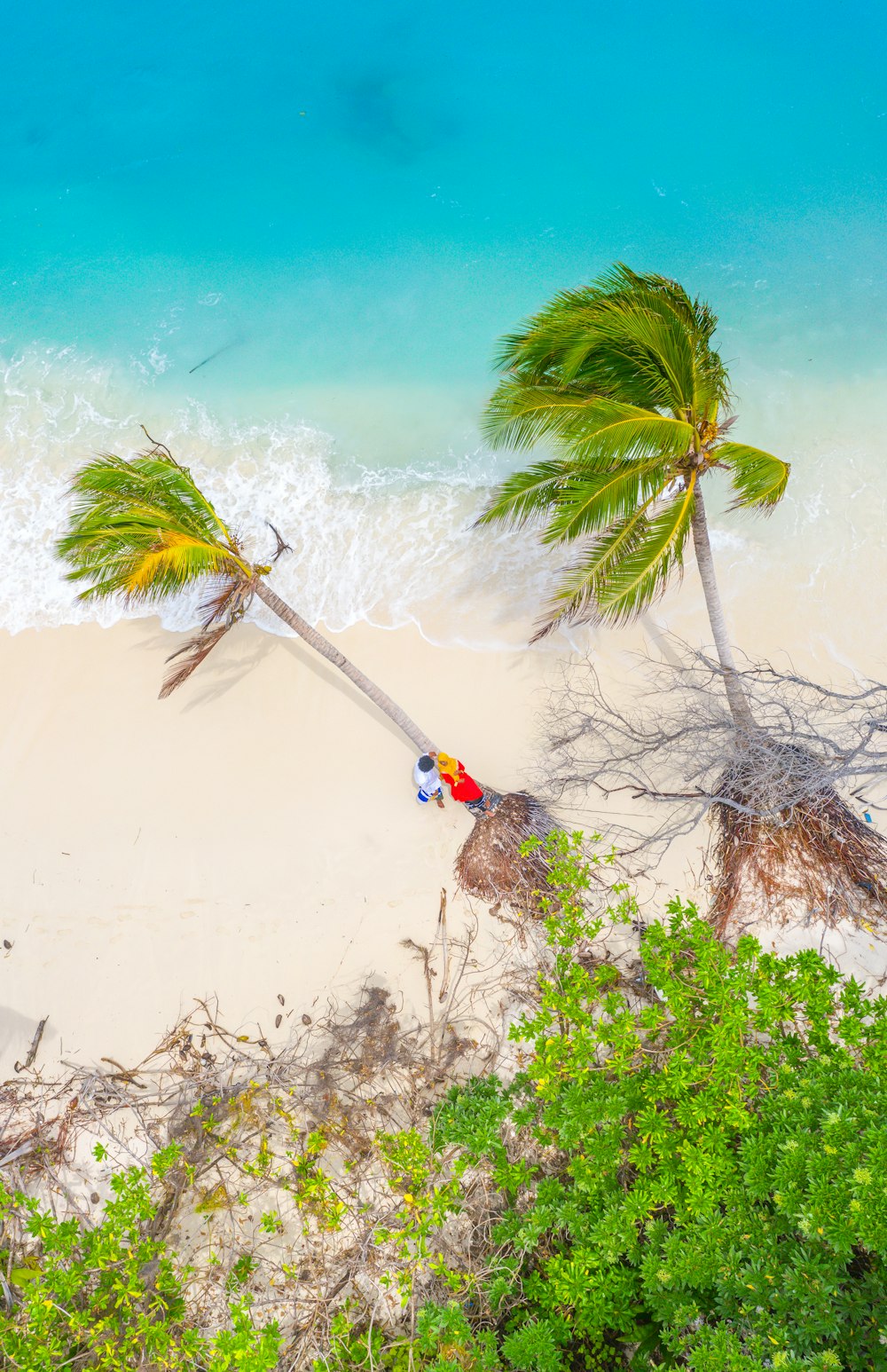 person in red shirt standing on white sand during daytime