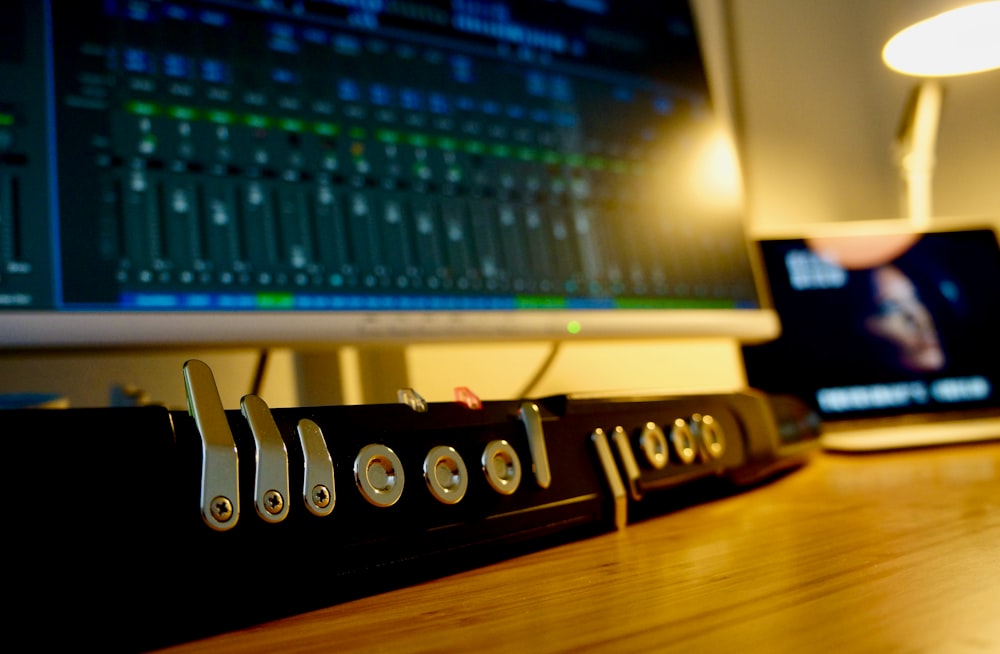 black and white speaker beside black flat screen computer monitor