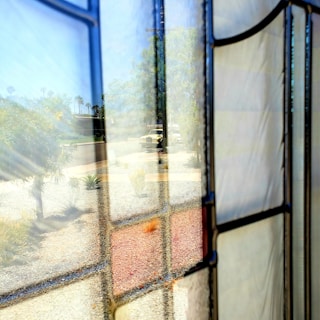 A clean, clear windshield on a car parked outside Gracewood Glass Shop, reflecting sunlight.