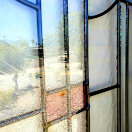 A clean, clear windshield on a car parked outside Gracewood Glass Shop, reflecting sunlight.
