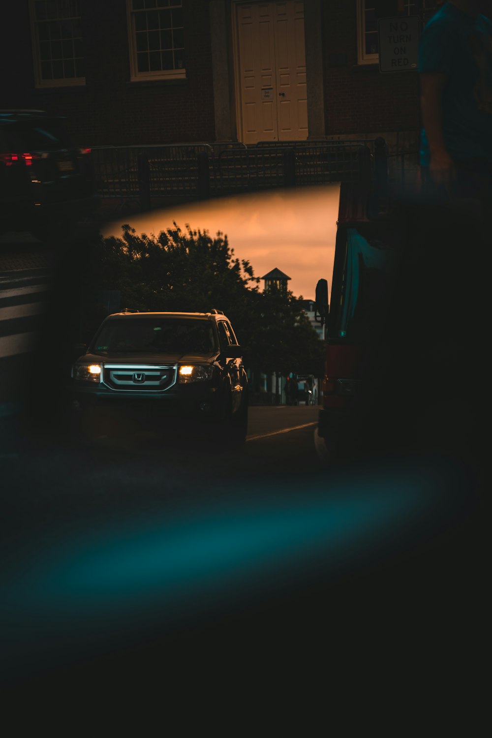 a car driving down a street next to a tall building