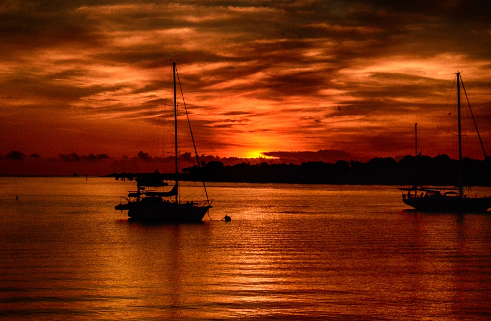 silhouette of boat on sea during sunset