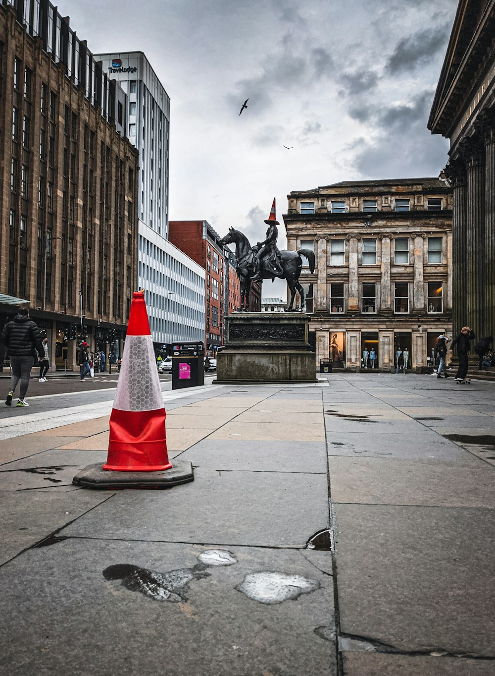 red and white traffic cone on gray concrete road