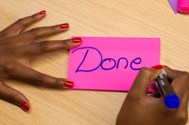 person with red manicure holding purple paper