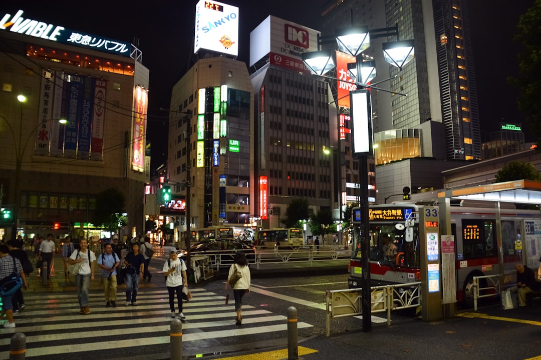 people walking on sidewalk near high rise buildings during night time