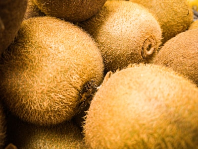 Close-up of ripe kiwis with a green background.