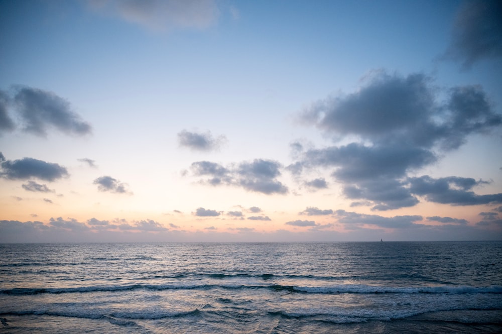 ocean waves under cloudy sky during daytime