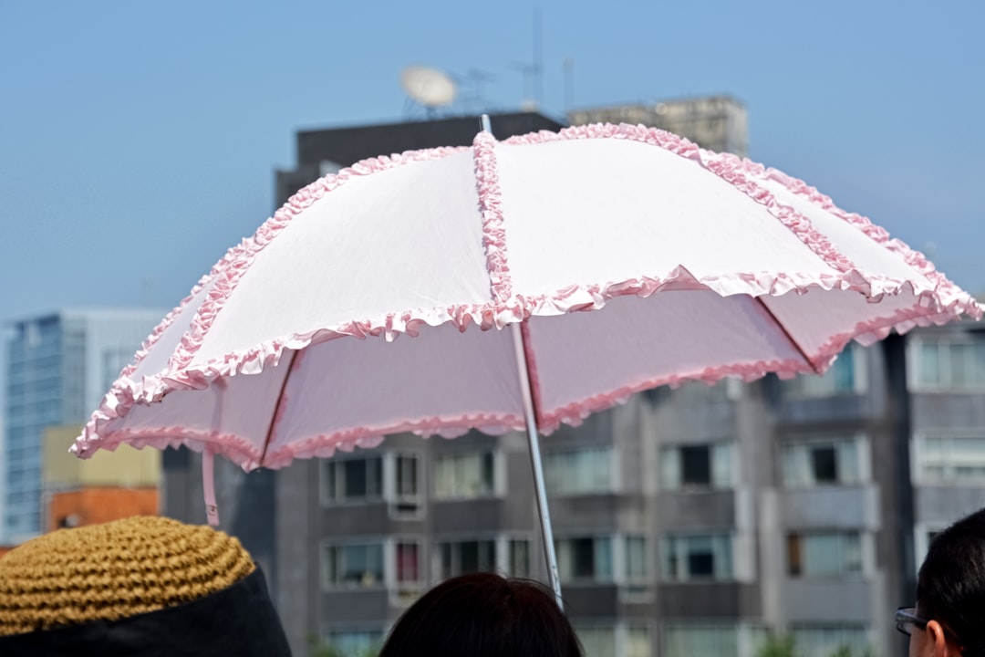person holding pink umbrella during daytime