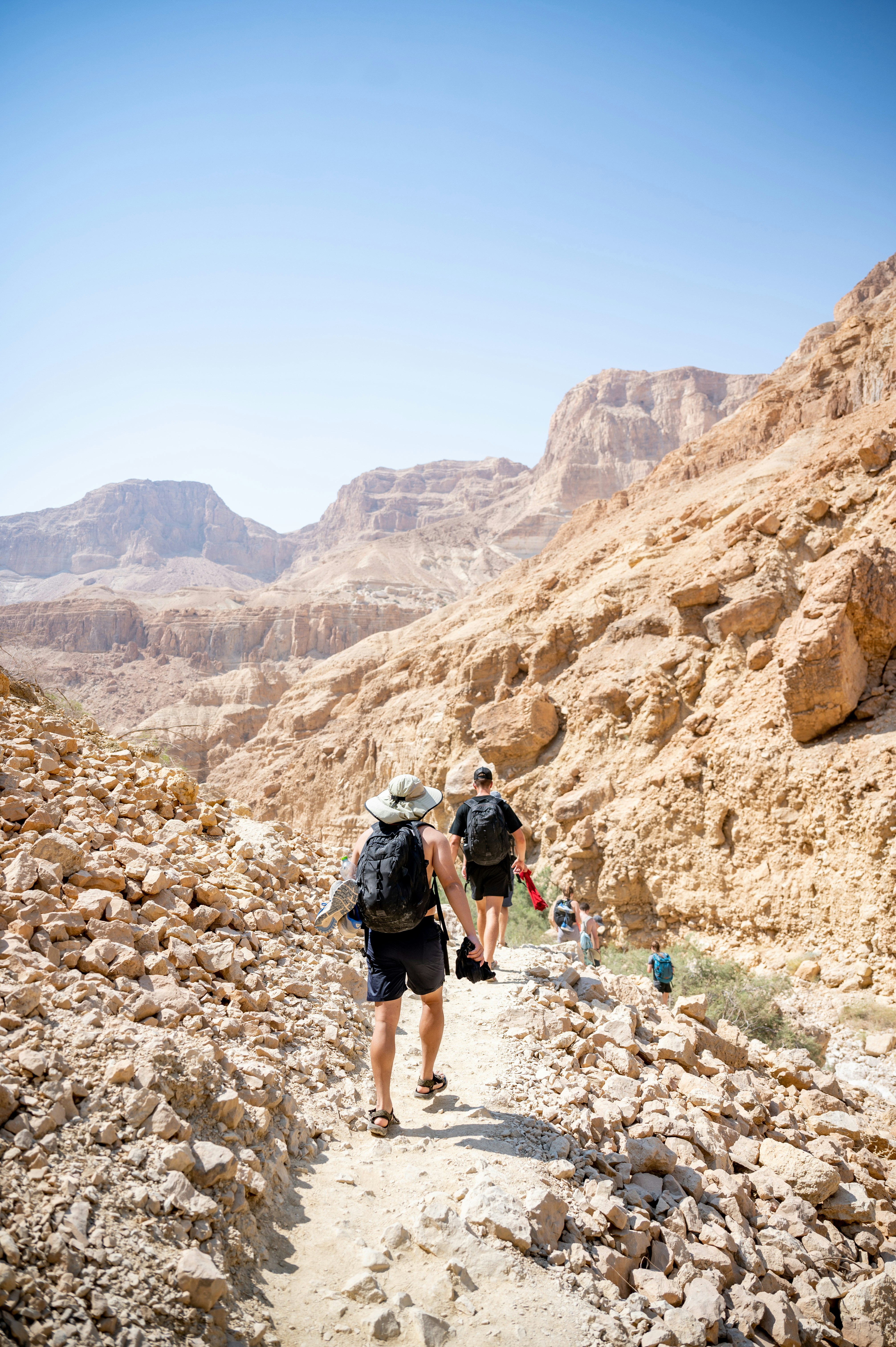 man in black t-shirt and black shorts walking on rocky mountain during daytime