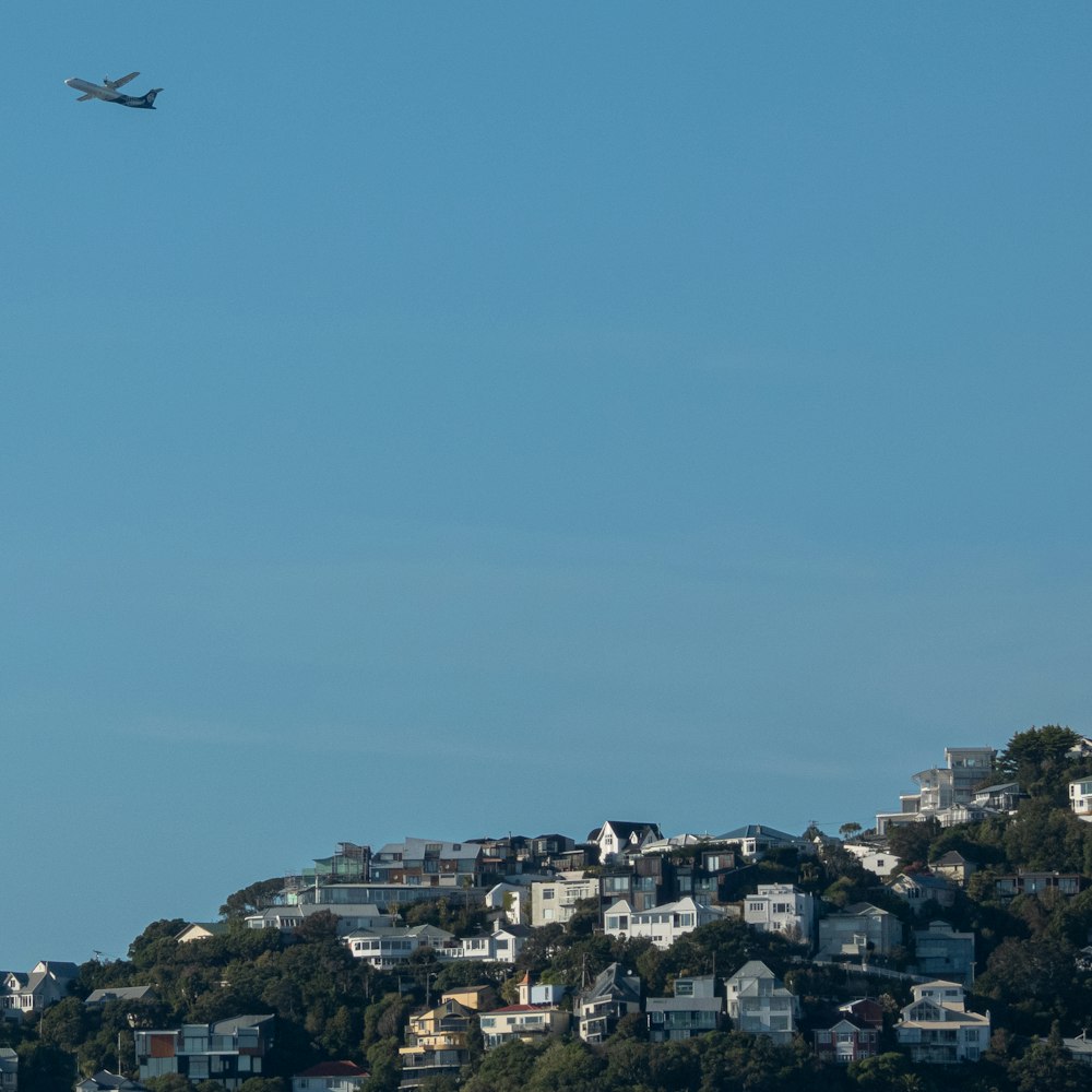 black airplane flying over city during daytime