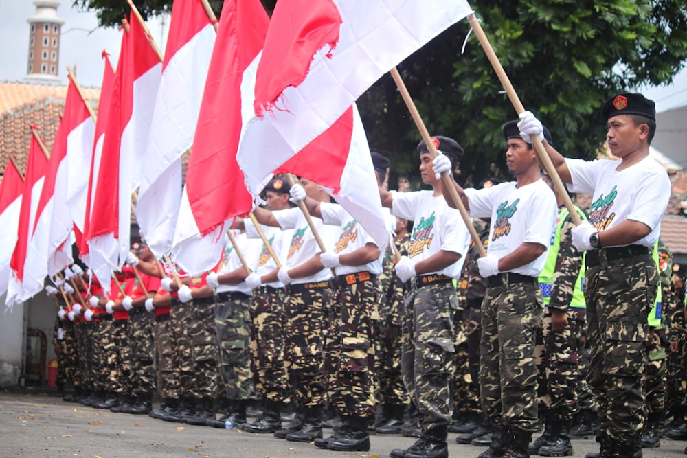 people in white shirts holding flags during daytime