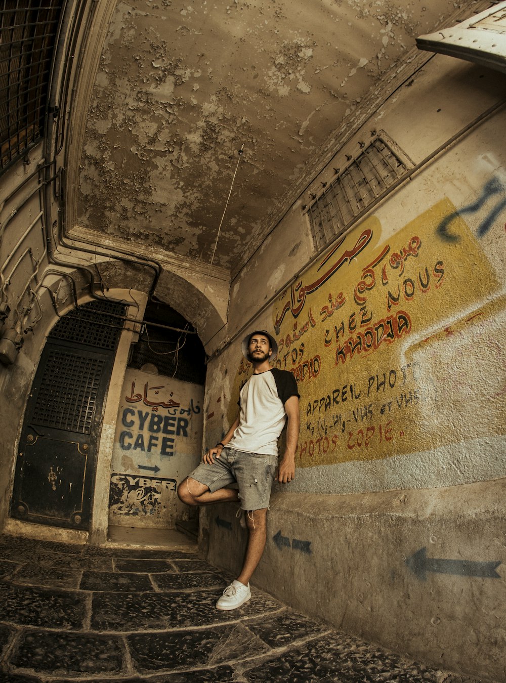 man in white t-shirt and blue denim shorts walking on hallway