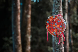 A rustic tambourine decorated with traditional Peruvian motifs against a backdrop of mountain scenery.
