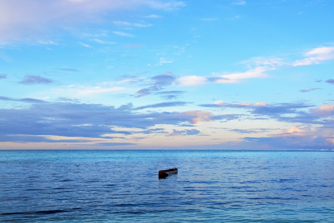 black boat on sea under blue sky during daytime