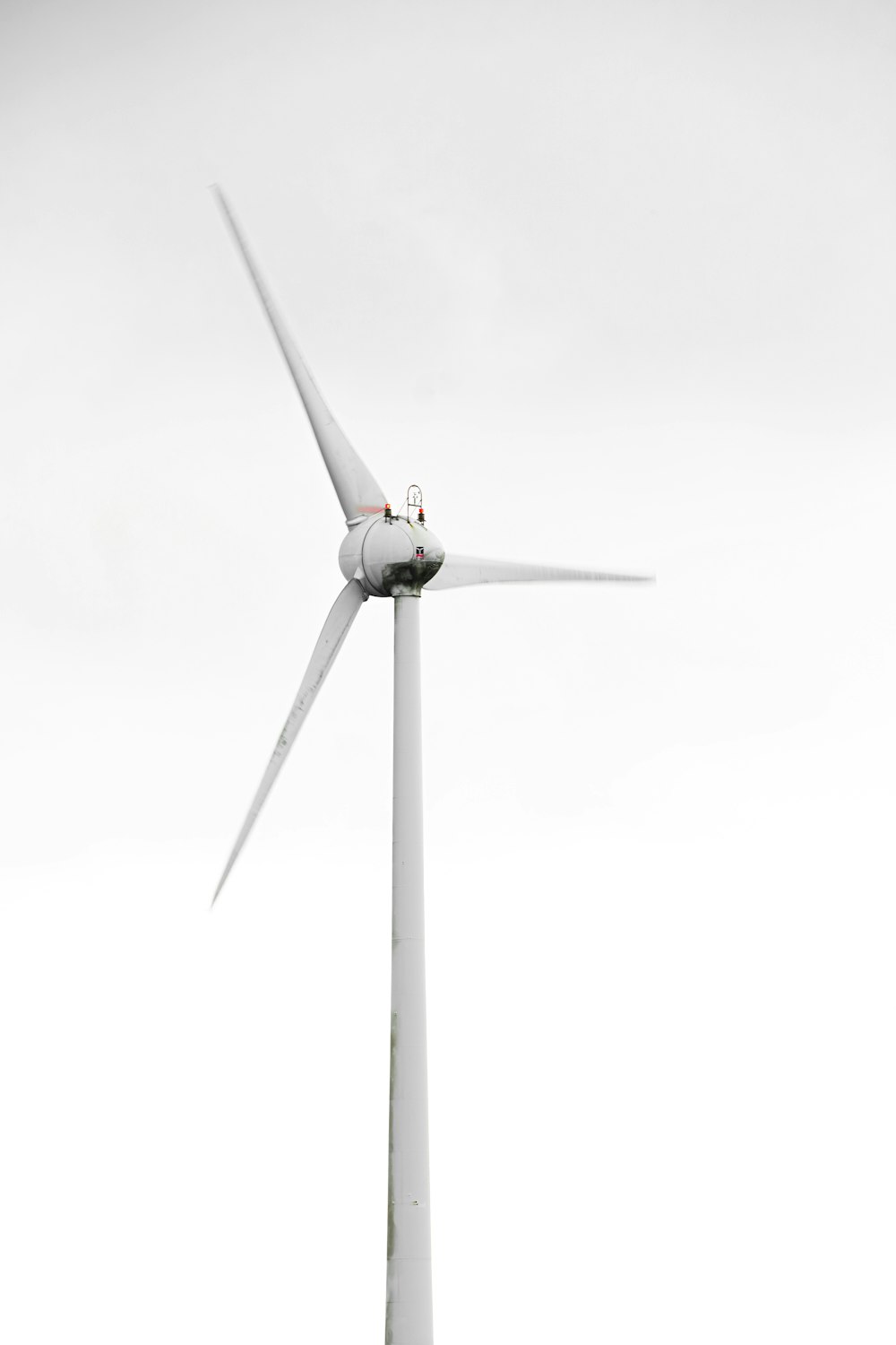 white wind turbine under white sky
