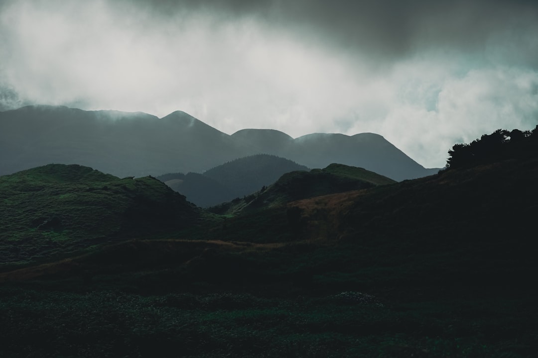 green mountains under white clouds