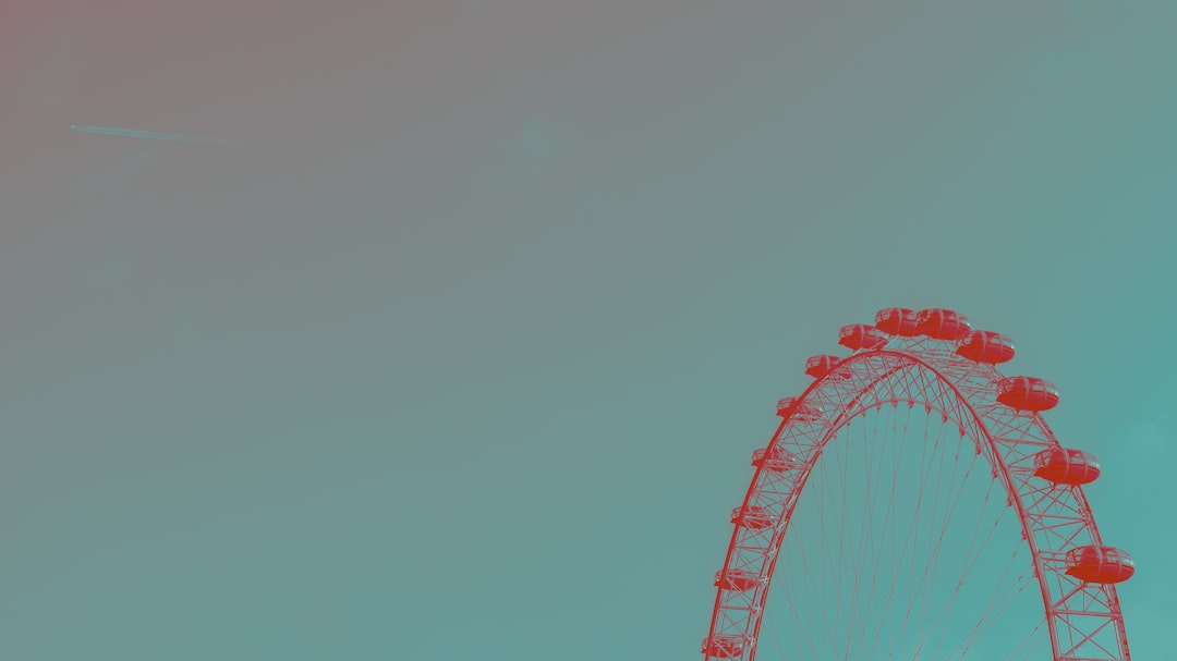 red and white ferris wheel under blue sky