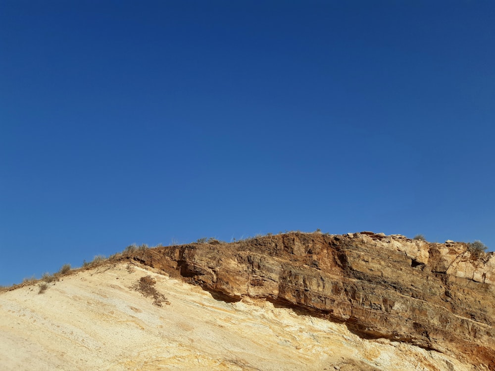 brown rocky mountain under blue sky during daytime