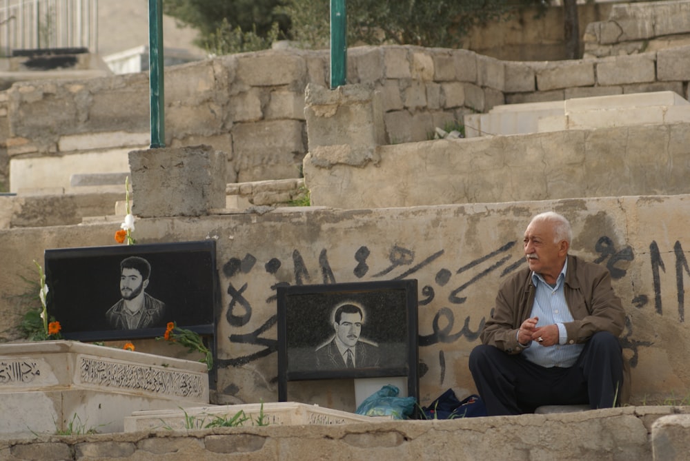 man in white dress shirt sitting on brown concrete bench