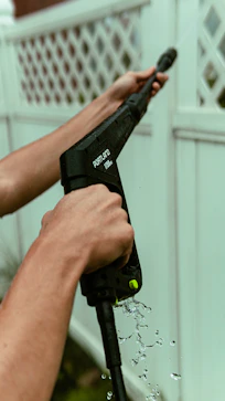 person holding black and green cordless power tool