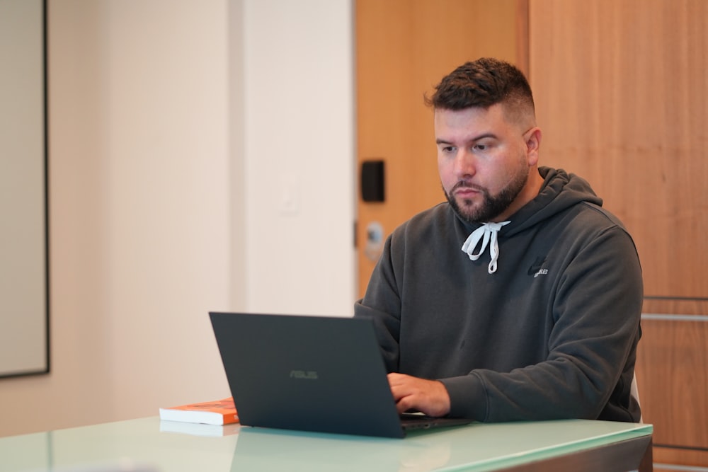 man in black nike jacket using macbook pro