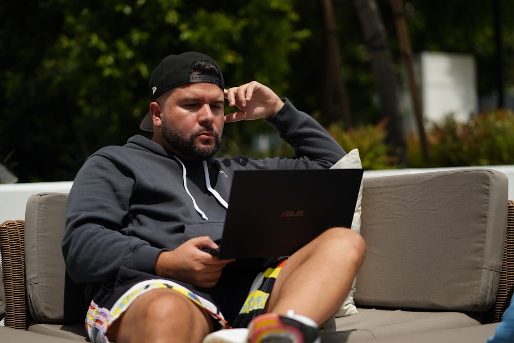 man in black hoodie using black laptop computer