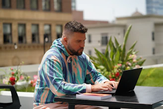 man in blue and white stripe dress shirt using black laptop computer