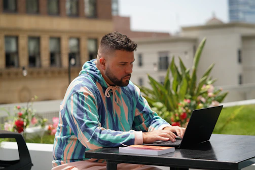 man in blue and white stripe dress shirt using black laptop computer