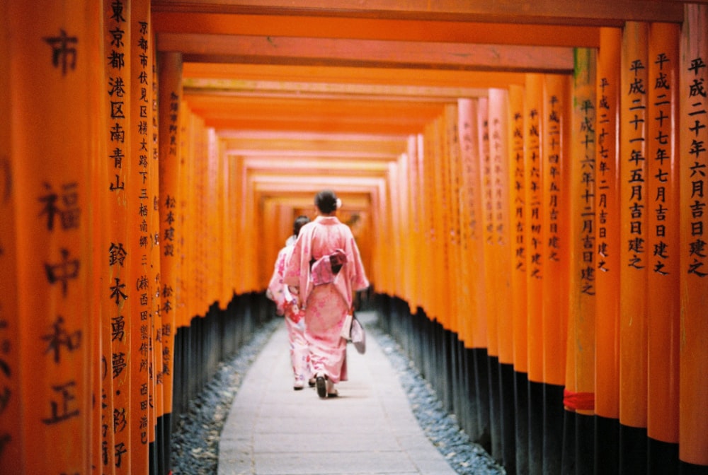 woman in pink and white kimono walking on hallway