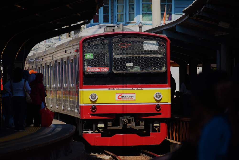 red and yellow train on rail during daytime