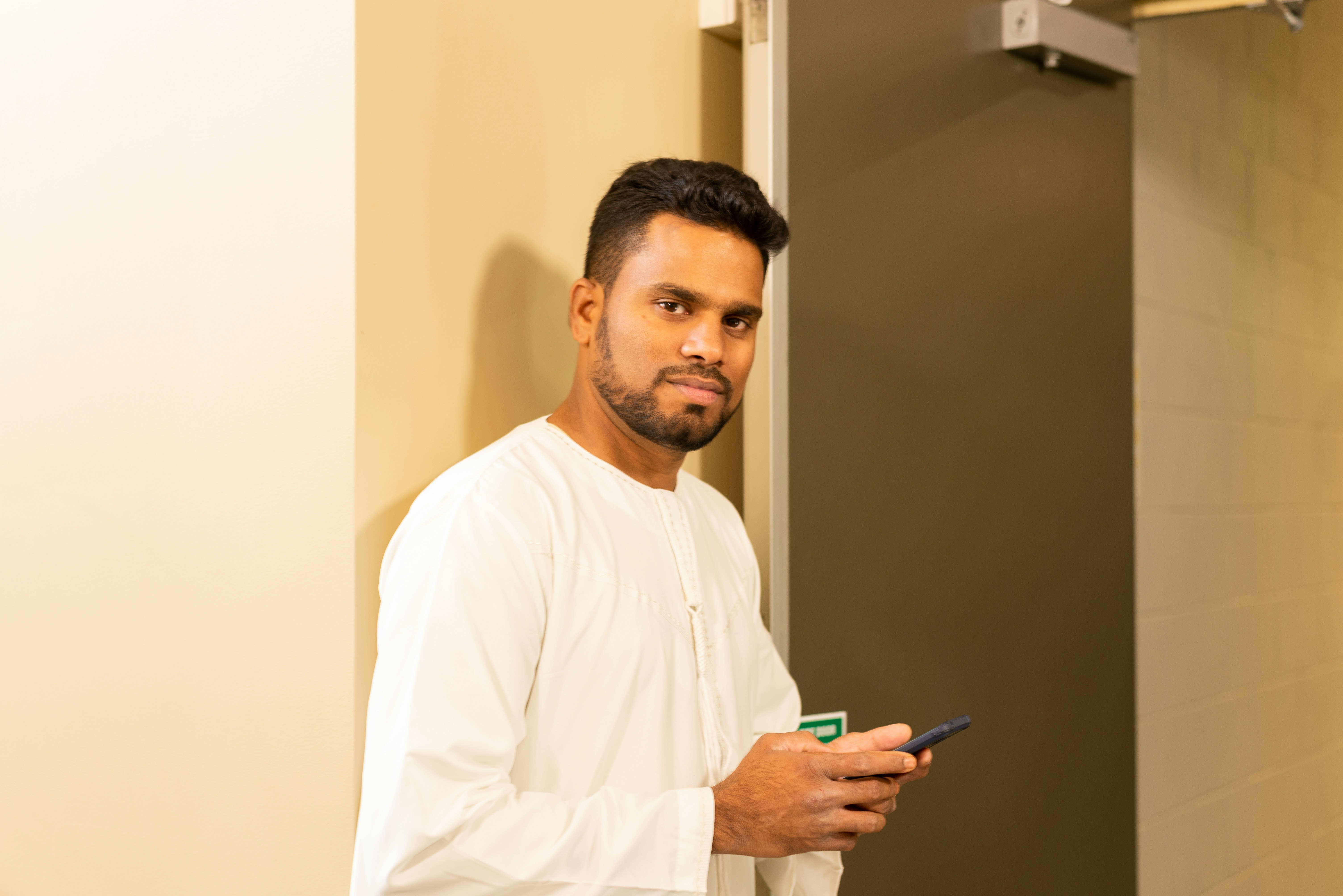 Resident using a smartphone to open their apartment door - Luxury building amenities