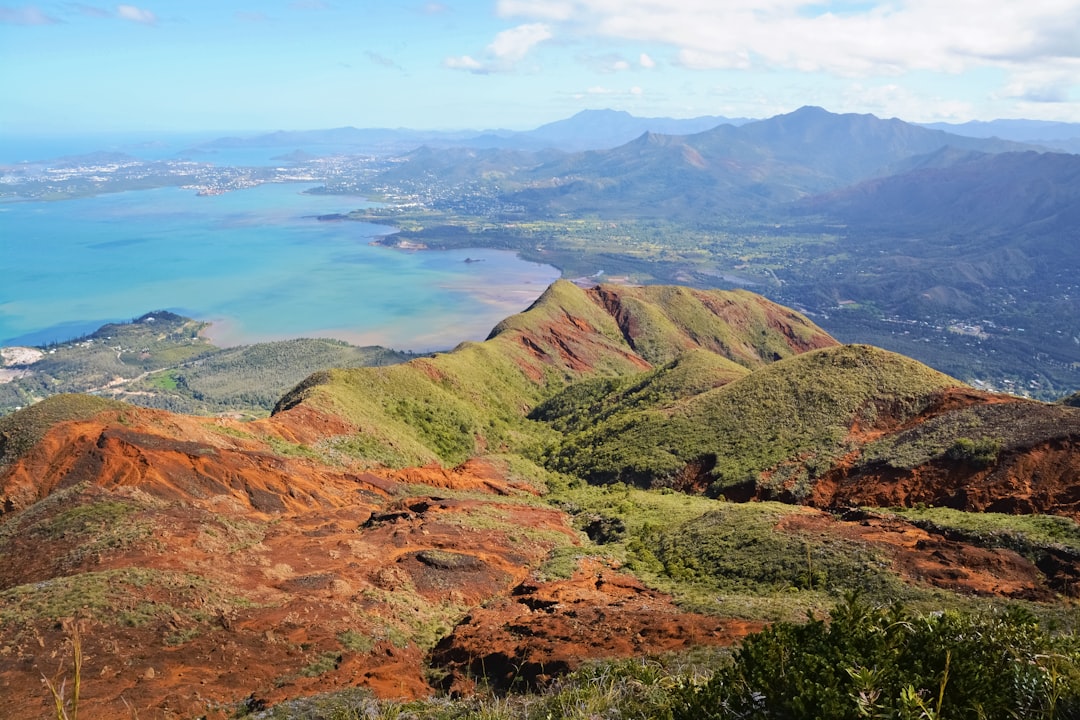 green and brown mountains near body of water during daytime