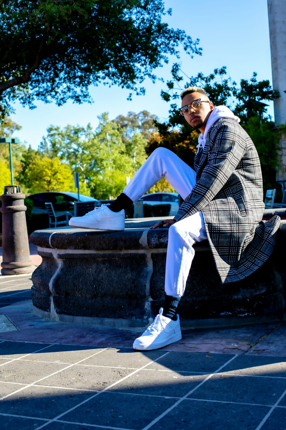 man in black and white pinstripe suit sitting on gray concrete bench during daytime