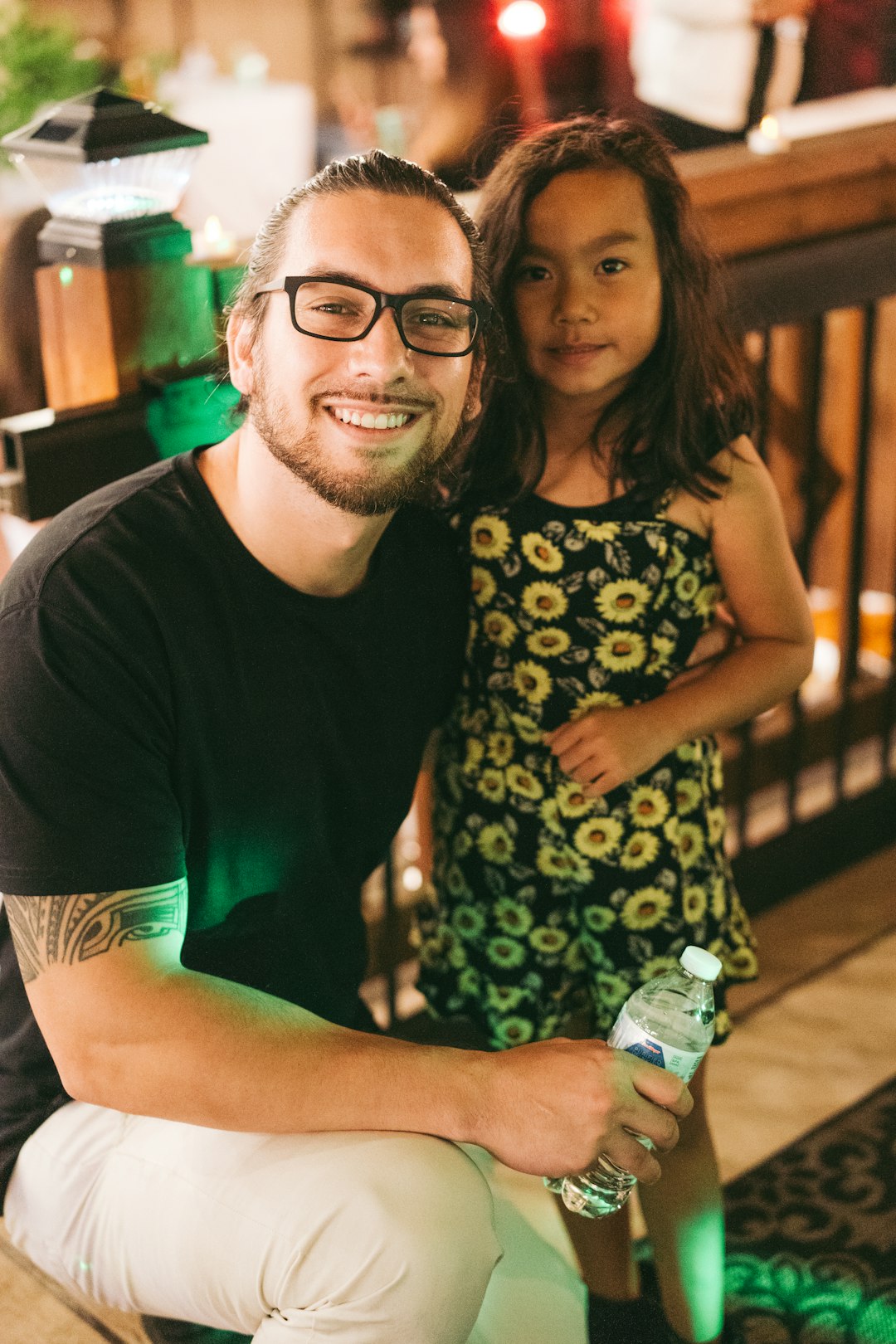 man in black crew neck t-shirt beside woman in green and white floral dress