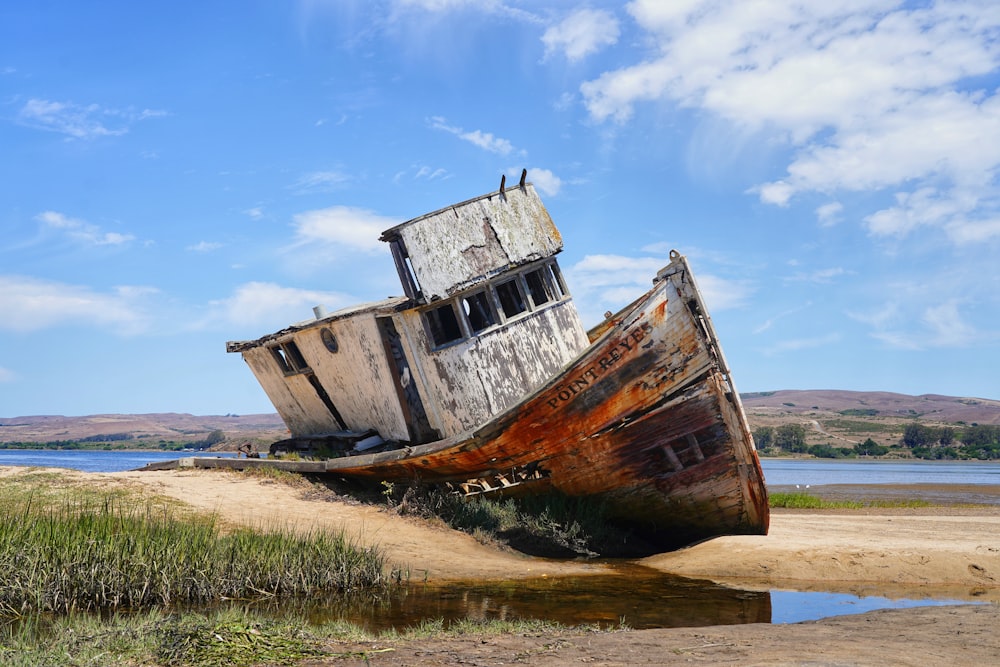 brown and white boat on green grass field under blue sky during daytime