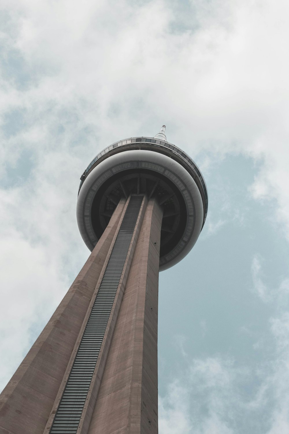 brown and white tower under white clouds and blue sky during daytime