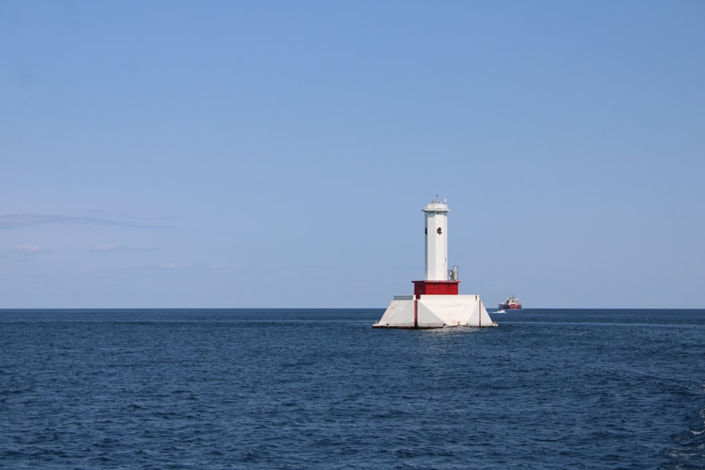 white and red lighthouse on the sea during daytime