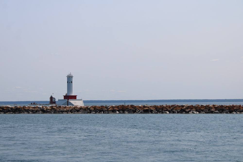 white lighthouse near body of water during daytime