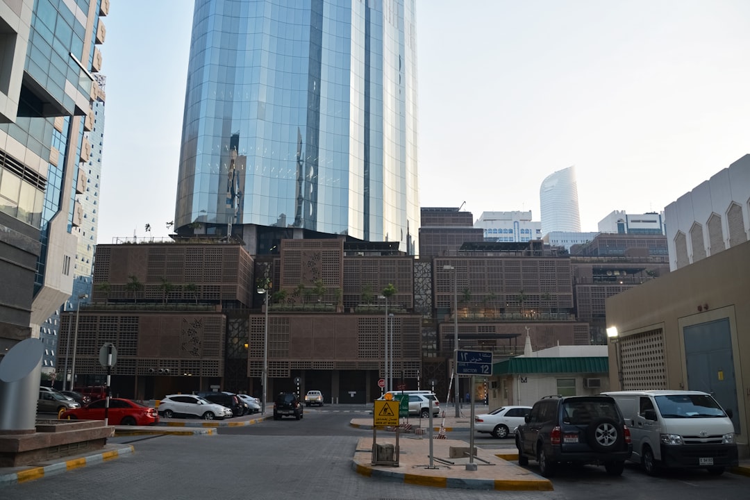 cars parked on parking lot near high rise building during daytime