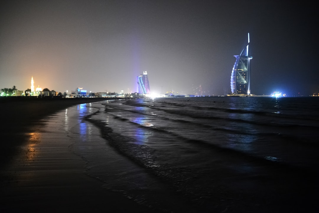 white and black tower near body of water during night time