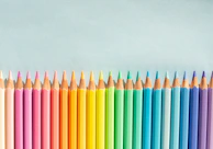 A collection of colorful pencils arranged in a gradient on a minimalist background.