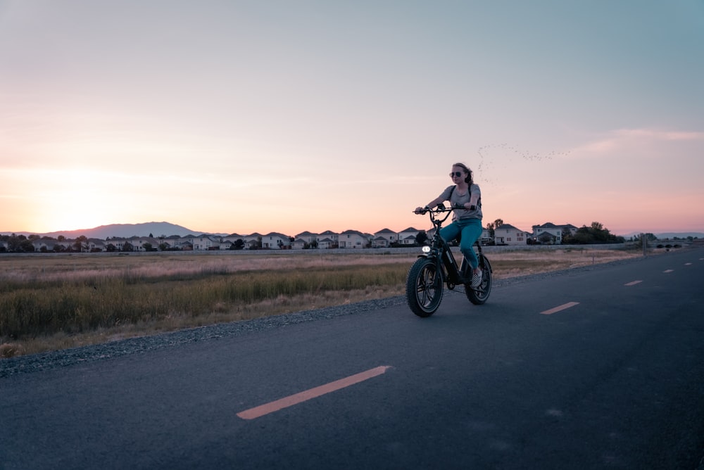 homme en chemise bleue conduisant une moto sur la route pendant la journée