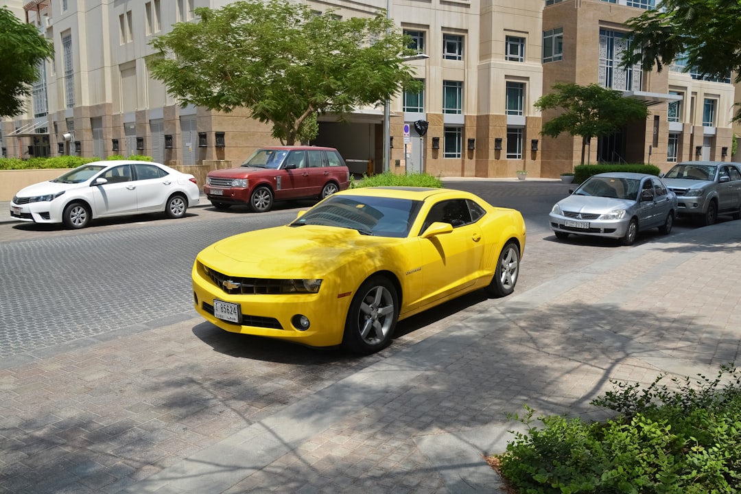 yellow chevrolet camaro parked on street during daytime